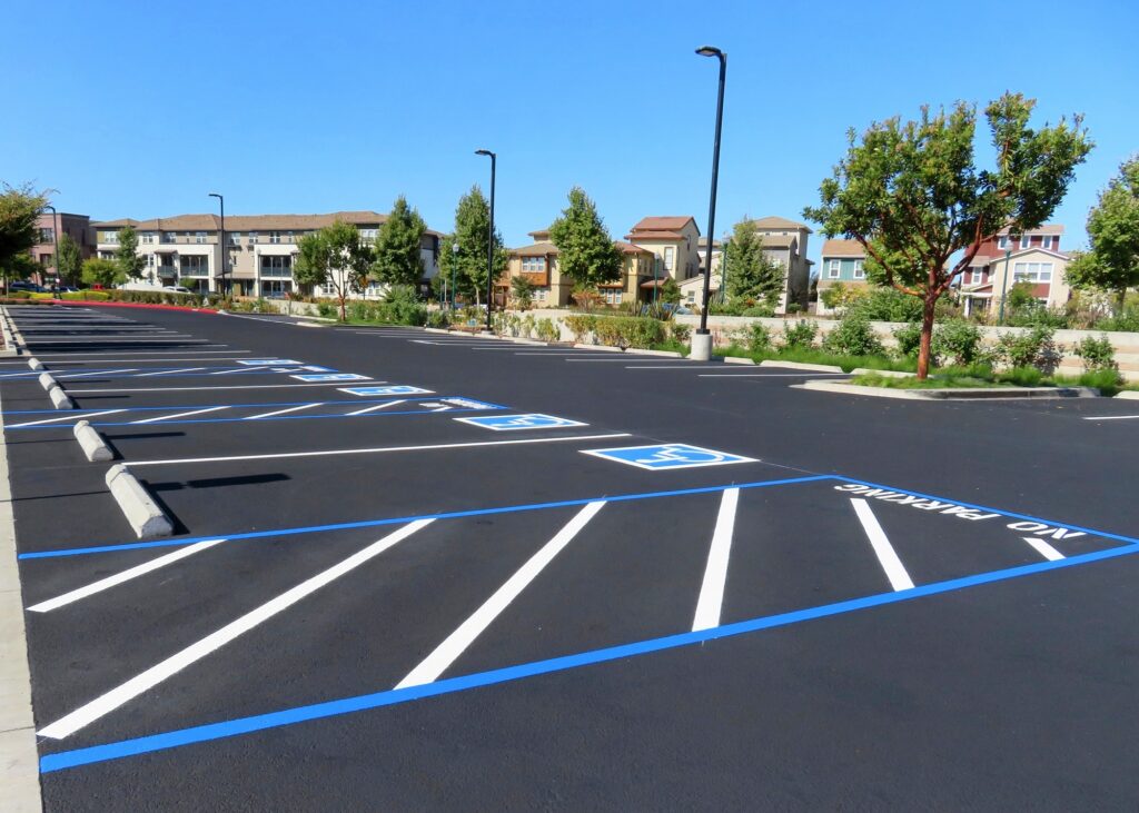 ADA Compliance Freshly resurfaced and repainted handicap parking space in a parking lot. The number of handicap spaces increases with the size of the lot, requiring roughly one handicapped spot per 25 spaces.