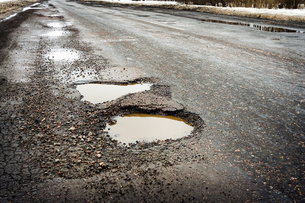 a road with many potholes after a heavy downpour