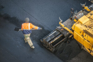 An above view of a machine and a person putting down new asphalt in El Paso.