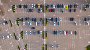 An aerial view of a large parking lot with scattered cars in El Paso.