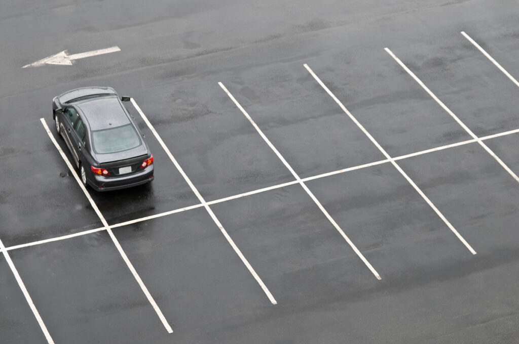 An aerial view of a parking lot with a parked grey car in El Paso.
