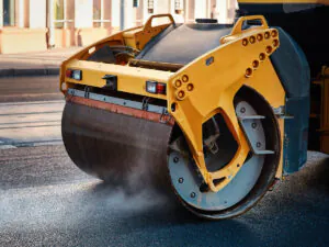 A machine rolling asphalt paving in El Paso.