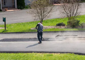 A person performing asphalt repair in El Paso.